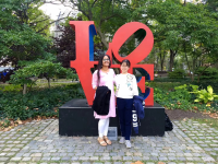 楊同學（右）和義工活動的朋友在賓夕法尼亞大學中央校園的「愛」(‘LOVE’) 字擺件前合照。
